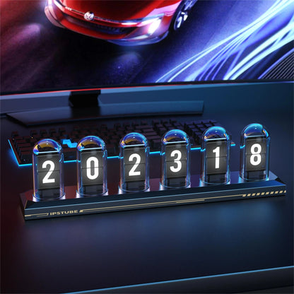 Digital clock with flip-style display in front of a computer screen