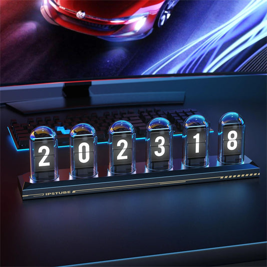 Digital clock with flip-style display in front of a computer screen