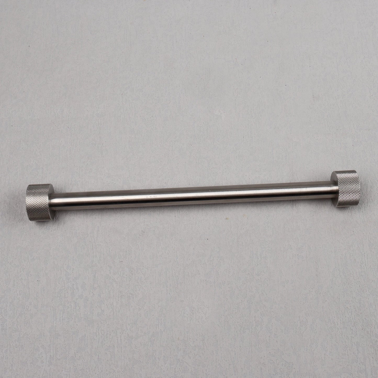 Metal rod with hexagonal ends on a gray background