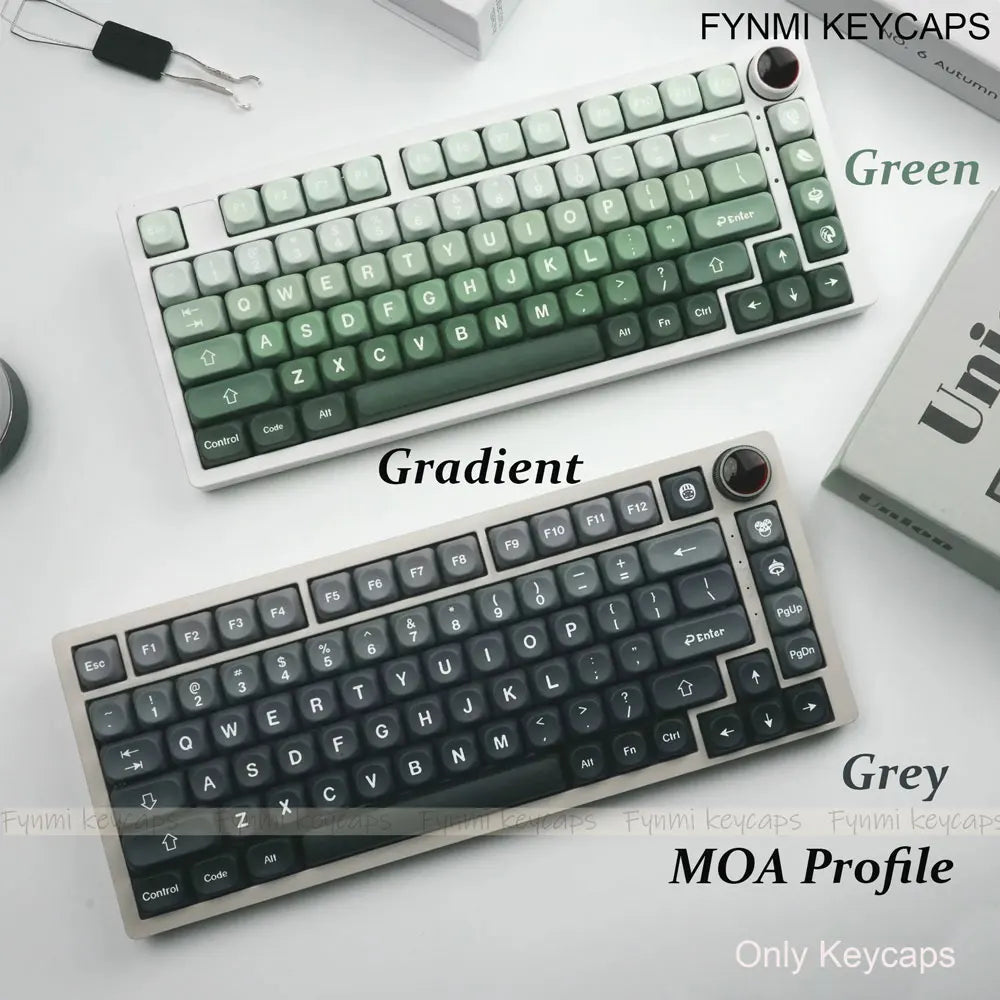 Two mechanical keyboards with gradient and gray keycaps on a white surface, featuring FYNMI Keycaps branding.