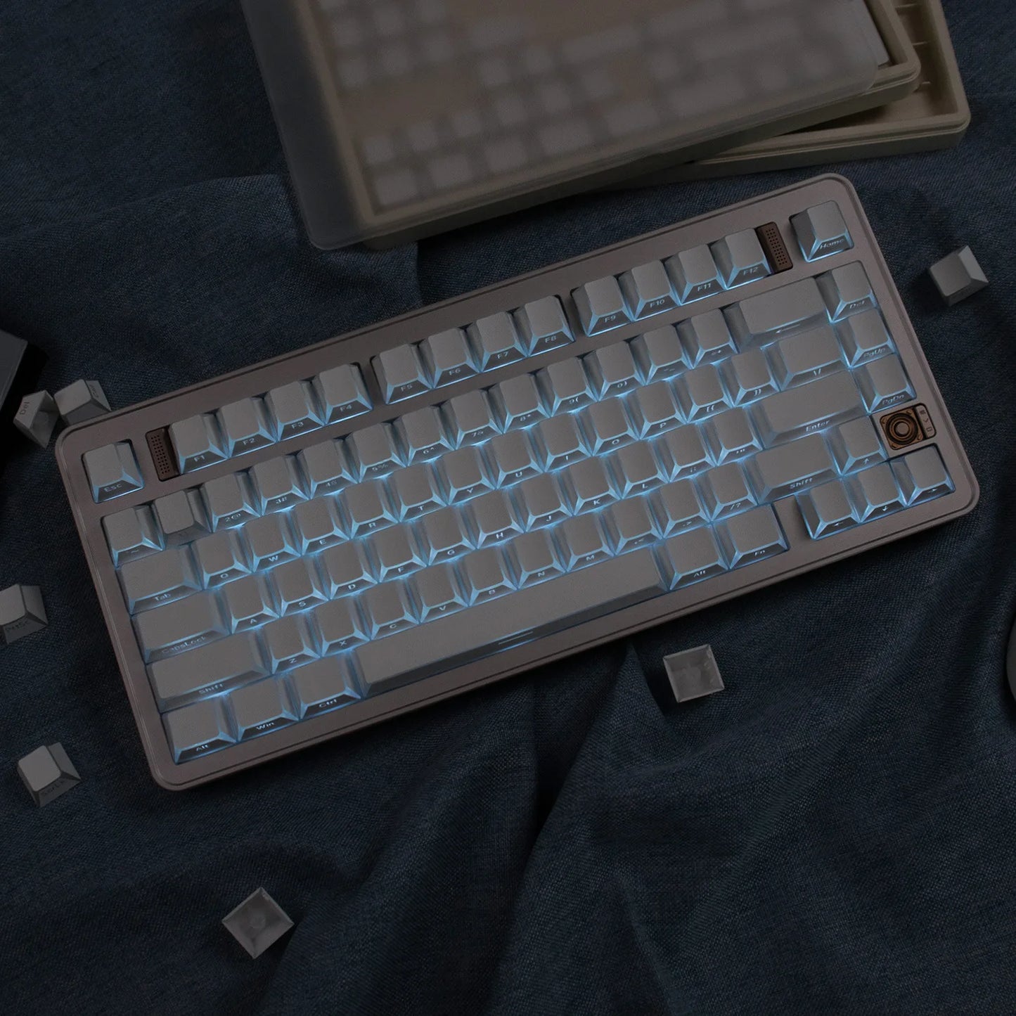 Mechanical keyboard with beige frame and white keys on a dark fabric background
