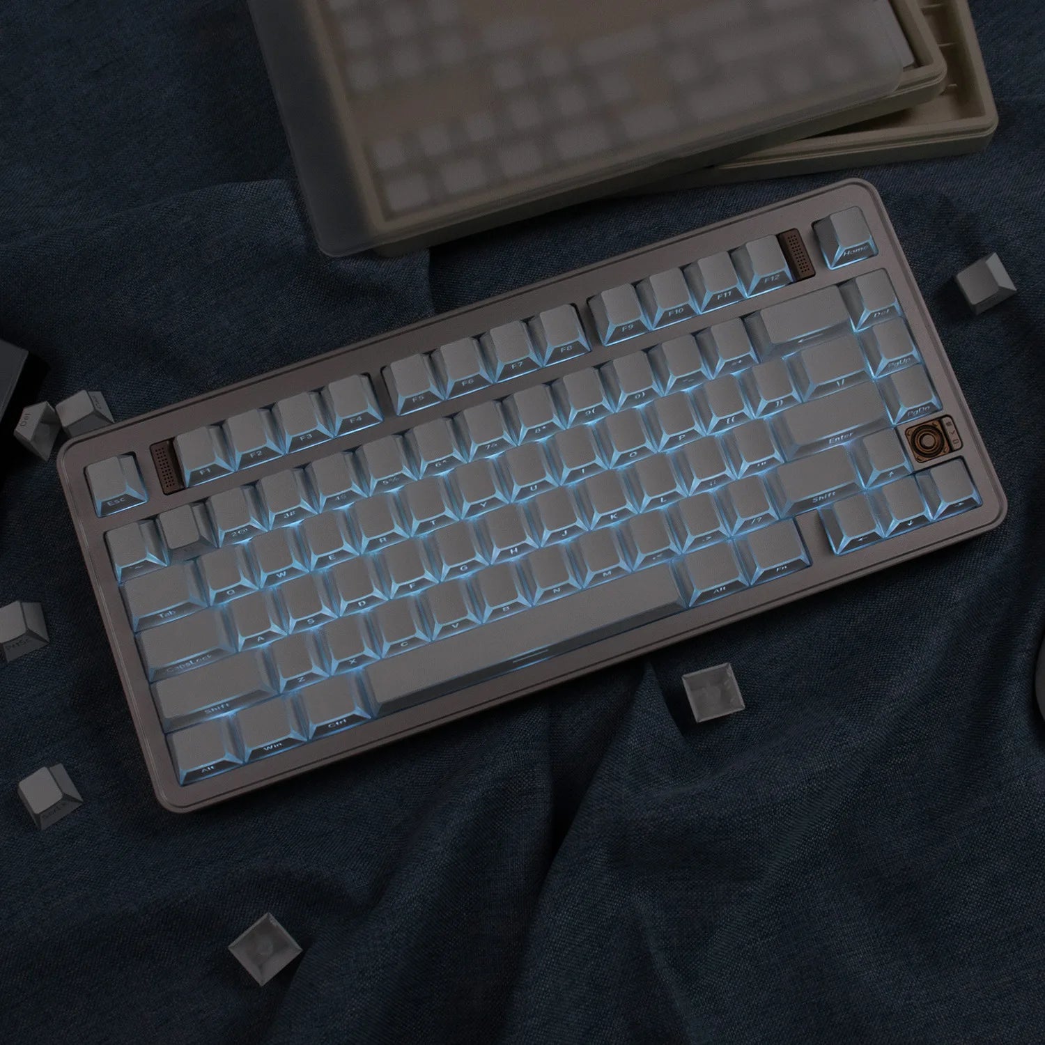 Mechanical keyboard with beige frame and white keys on a dark fabric background