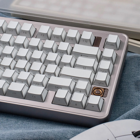 Close-up of a mechanical keyboard with white and gray keys on a blue fabric background