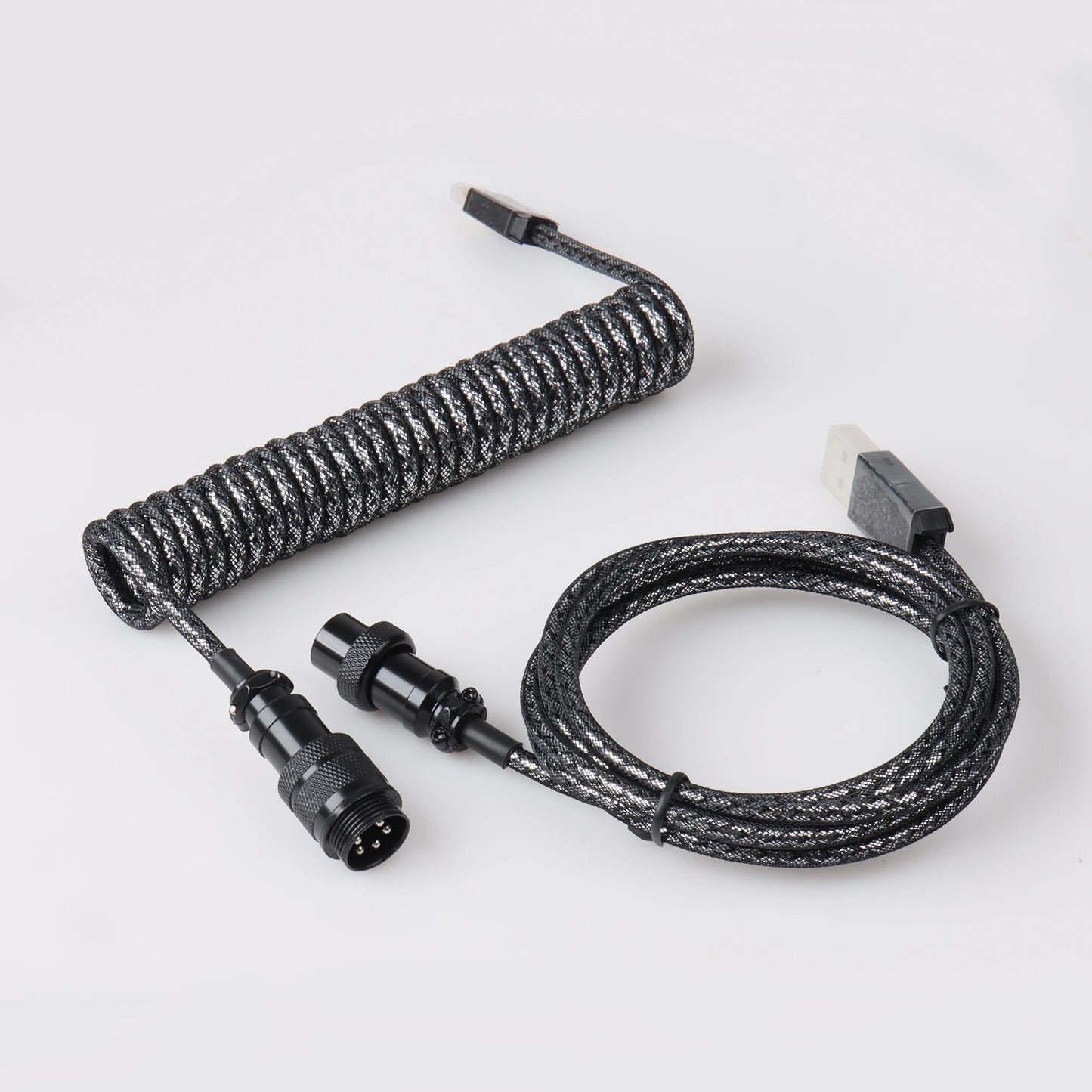 Coiled black cable with connectors on a white background