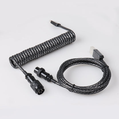 Coiled black cable with connectors on a white background