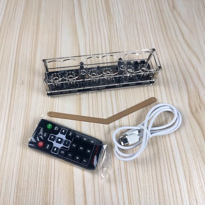 Electronic components including a remote control, USB cable, and printed circuit board on a wooden surface.