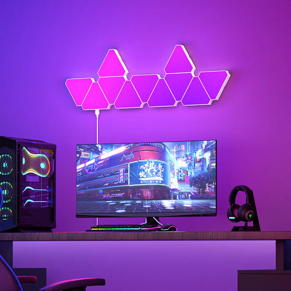 Neon triangle wall lights in a gaming setup with a computer monitor and RGB lighting.