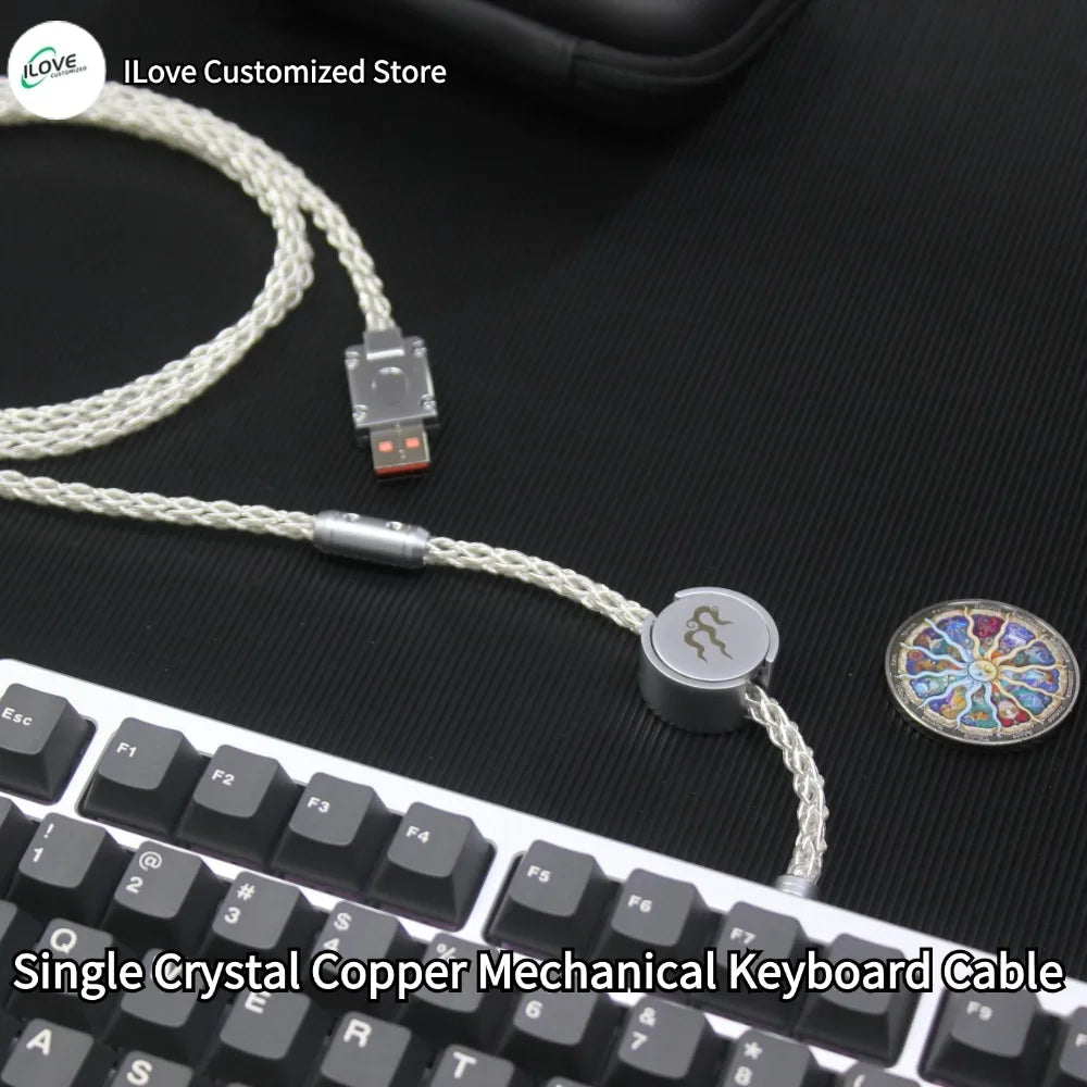 Single Crystal Copper Mechanical Keyboard Cable on a black surface with keyboard in the foreground