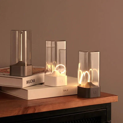 Three glass table lamps on a wooden surface with a neutral background