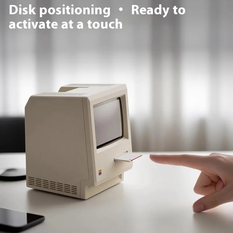 Vintage computer monitor with a hand inserting a disk, text 'Disk positioning - Ready to activate at a touch' above.