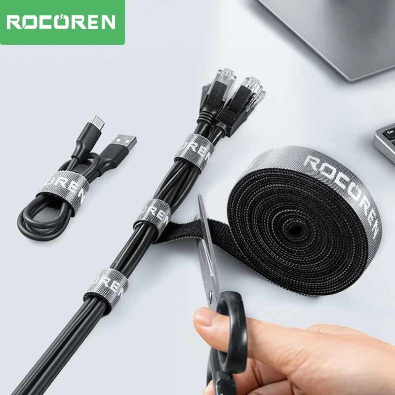Black cables with 'ROCOREN' branding, scissors, and a roll of black tape on a light gray background.