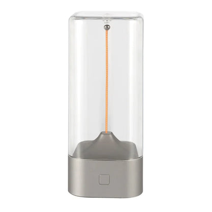 Clear glass container with a metallic base on a white background