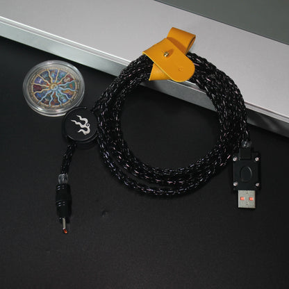 Black braided cable with USB connector on a dark surface
