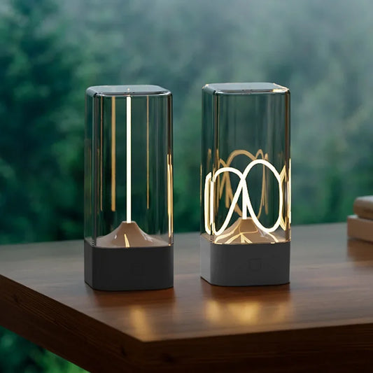 Two modern table lamps on a wooden surface with a blurred green background