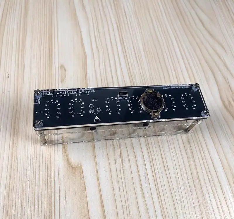 Electronic module with control knobs and display on a wooden surface