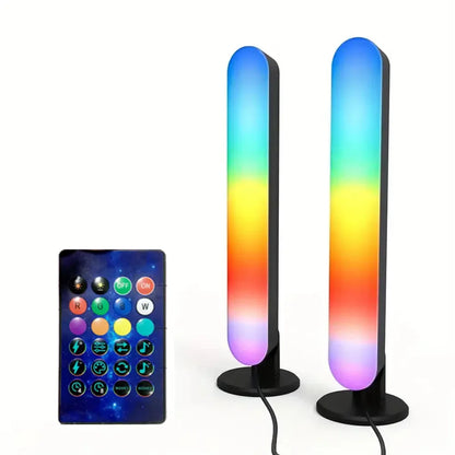 Two tall, cylindrical LED lamps with a gradient color effect and a remote control on a white background.