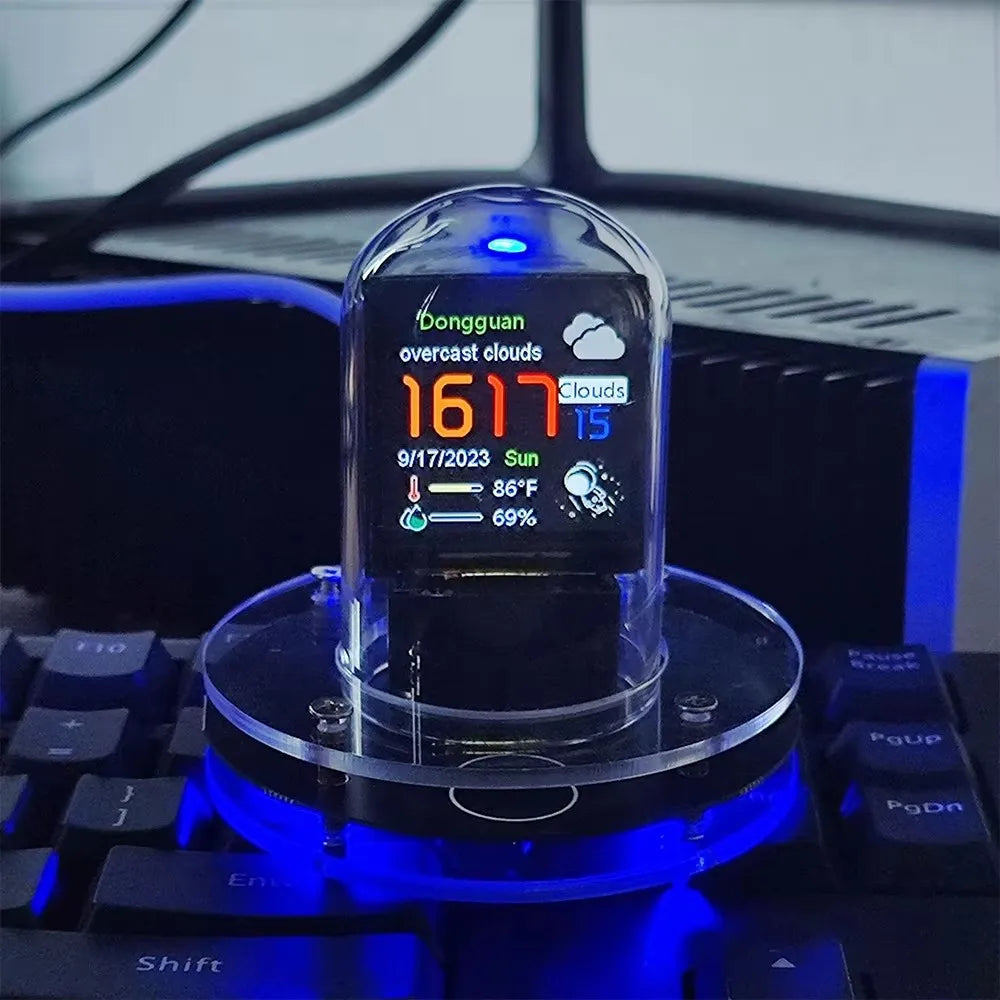 Digital display on a clear stand with blue lighting, placed on a keyboard.