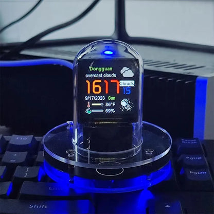 Digital display on a clear stand with blue lighting, placed on a keyboard.
