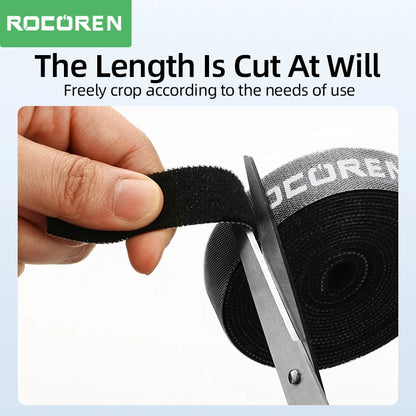 Person cutting black tape with scissors, ROCOREN branding visible