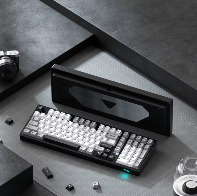 Mechanical keyboard on a gray surface with a black box in the background