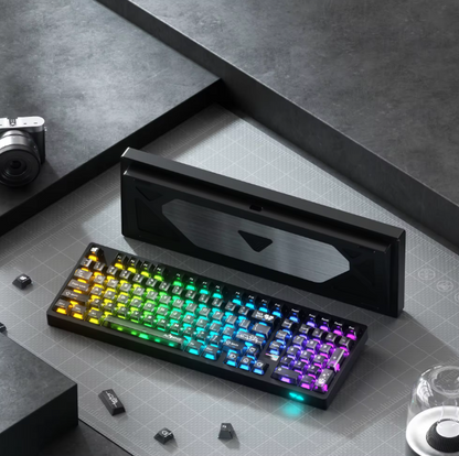 Colorful mechanical keyboard on a gray surface with a camera and other items.