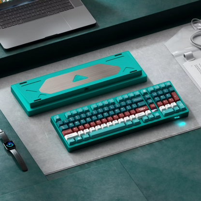 Teal keyboard with red and white keys on a desk with a laptop and mouse.