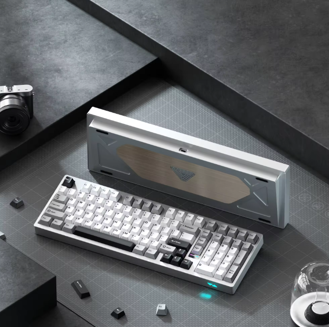 Mechanical keyboard on a dark surface with a camera and glass in the background