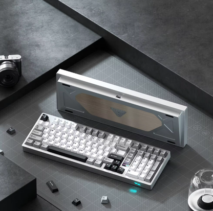 Mechanical keyboard on a dark surface with a camera and glass in the background